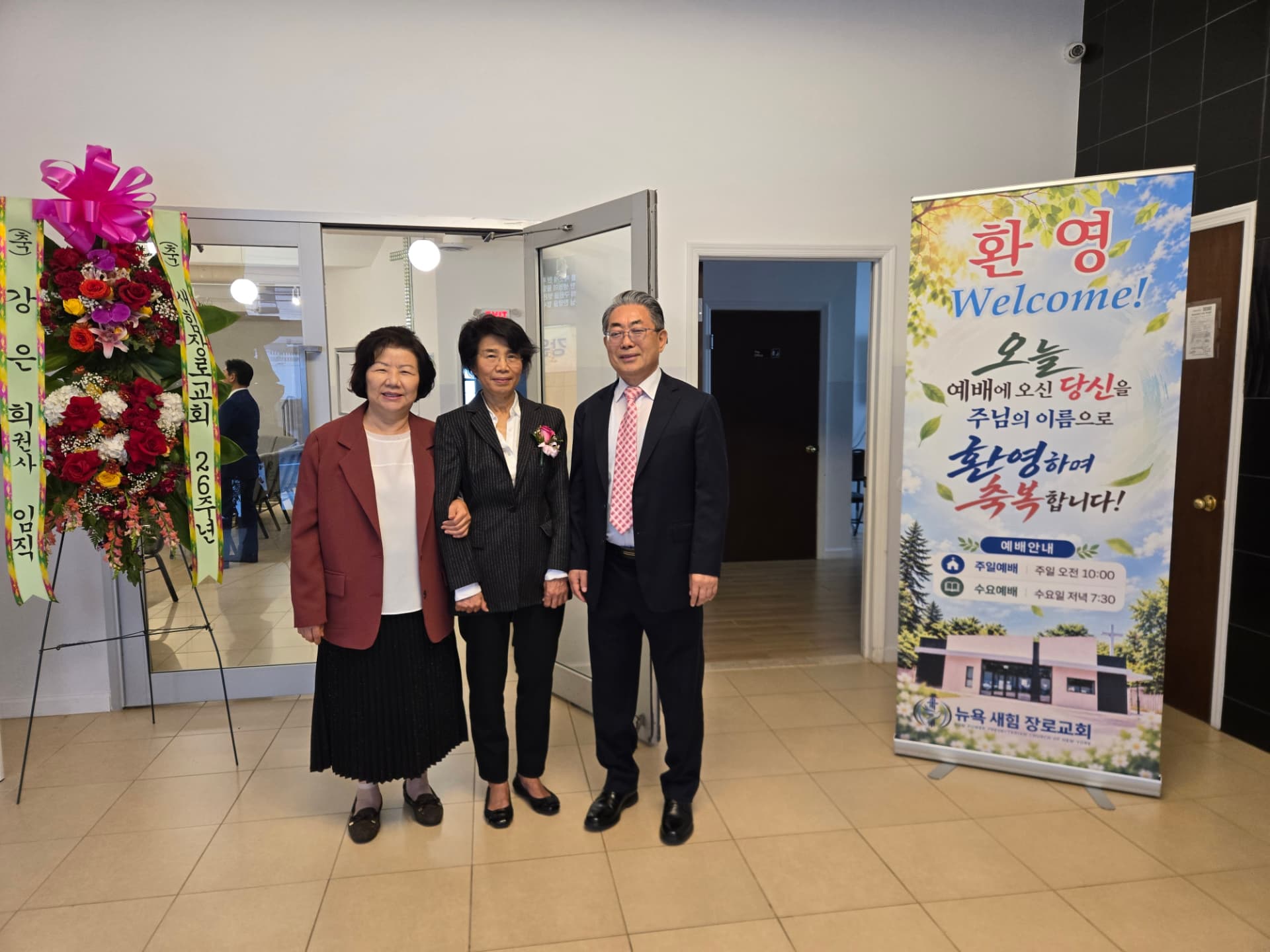 「환영 Welcome!」 배너와 꽃 화환 앞에서 함께한 내빈들